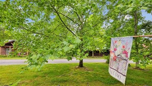 A residential area with a house, a tree, and a welcome banner. - Serene Cozy Cabin w/ Hot Tub & Games (Sevierville)