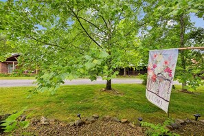Zona residencial con una casa, un árbol y un cartel de bienvenida.