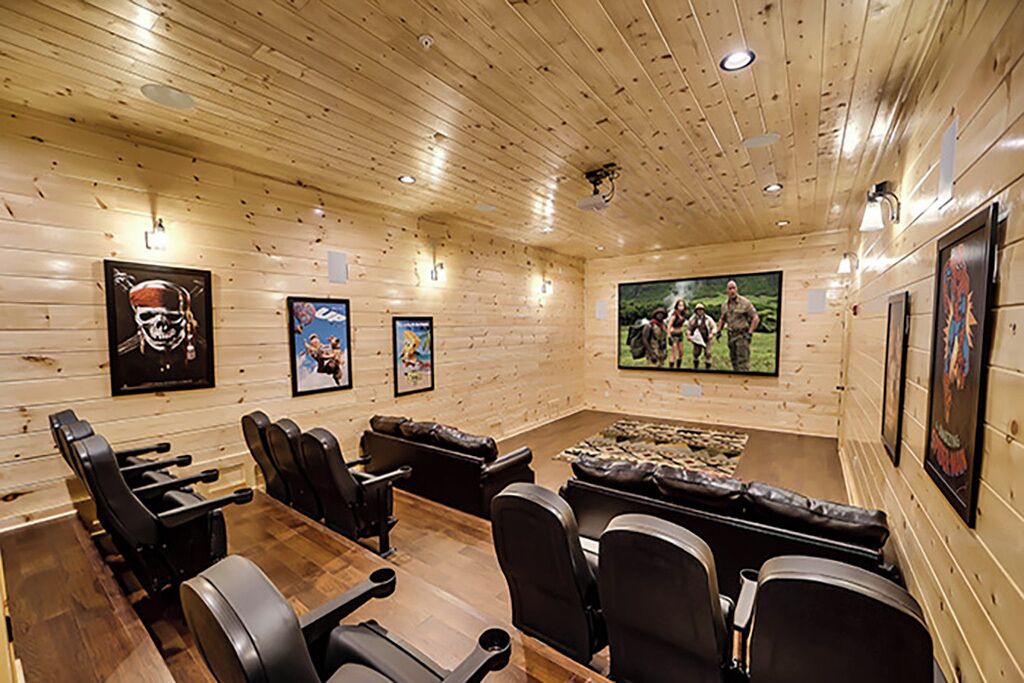 A conference room with wooden walls, a wooden table, leather chairs, and framed pictures on the walls.