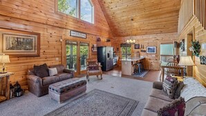 A log cabin interior with a living room, kitchen, and dining area. - Mountain Cabin w/ Hot Tub & Fireplace (Sevierville)