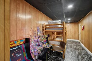 A room with a bunk bed, a gaming console, and a decorative tree. - 4BR Home | Theater + Hot tub + Games + Fire Pit (Gatlinburg)