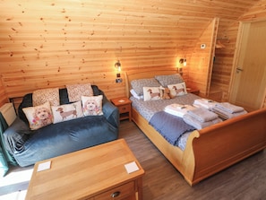 Ein gemütliches Holzhütten-Zimmer mit einem Bett, einer Couch und einem kleinen Tisch.