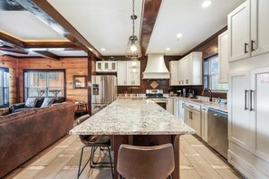 A kitchen with a central island, stainless steel appliances, and a wooden ceiling. - Gorgeous Mountain Views & Private Indoor Pool Await (Gatlinburg)