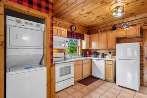 A kitchen with wooden cabinets, a microwave, a stove, a dishwasher, and a refrigerator. - Luxury Mountain Retreat w/ Hot Tub & Views (Pigeon Forge)