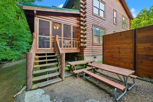Eine rustikale Holzhütte mit Veranda und Picknicktisch.