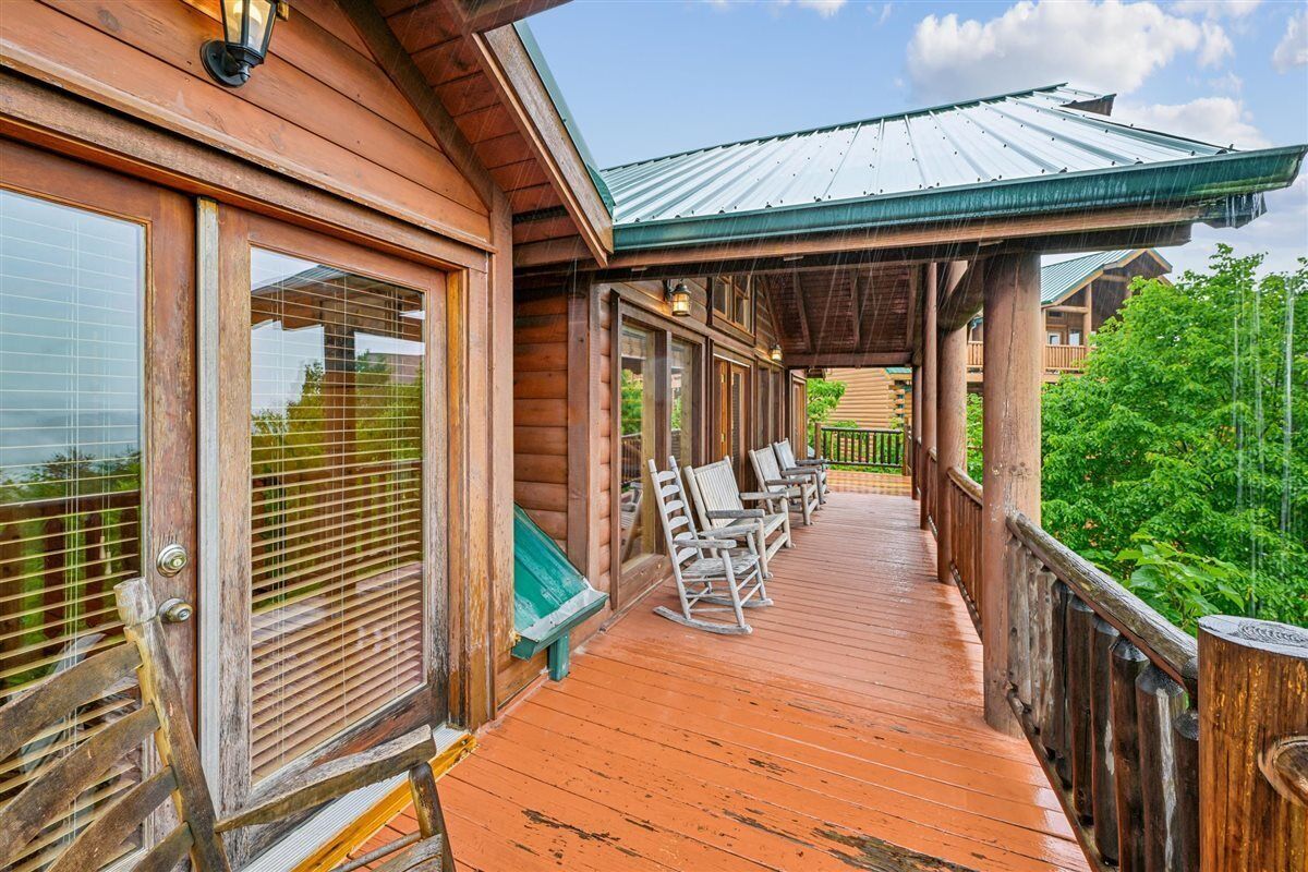A wooden building with a covered porch, large windows, and outdoor seating.