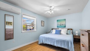 A bedroom with a bed, a ceiling fan, a window, and a dresser. - Stratford Holiday Home: Perfect for Families (Stratford)