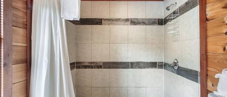 A shower area with wooden beams, tiled walls, and a showerhead.