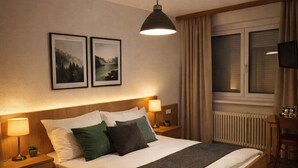 A neatly arranged bedroom with a wooden bed, two bedside lamps, a nightstand, a window with curtains, and two framed pictures on the wall. - 1 room 59€ (double bed 2person) (Ansfelden)