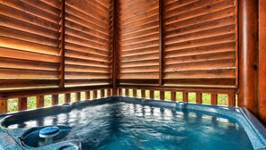 A hot tub with wooden slats on the walls and a wooden deck surrounding it. - Grand Mountain Retreat w/ Games & Hot Tub (Pigeon Forge)