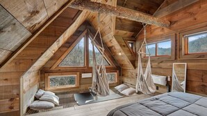 A wooden cabin with a loft bedroom, a hammock, a yoga mat, and a bed. - Rustic Wooded Escape w/ Hot Tub and Views (Sevierville)