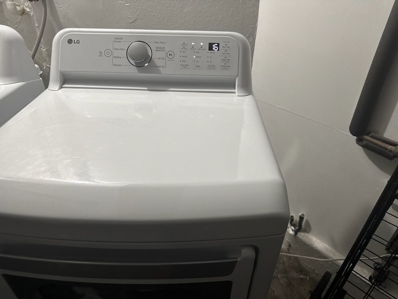 A front view of a white LG washing machine with a control panel displaying various settings.