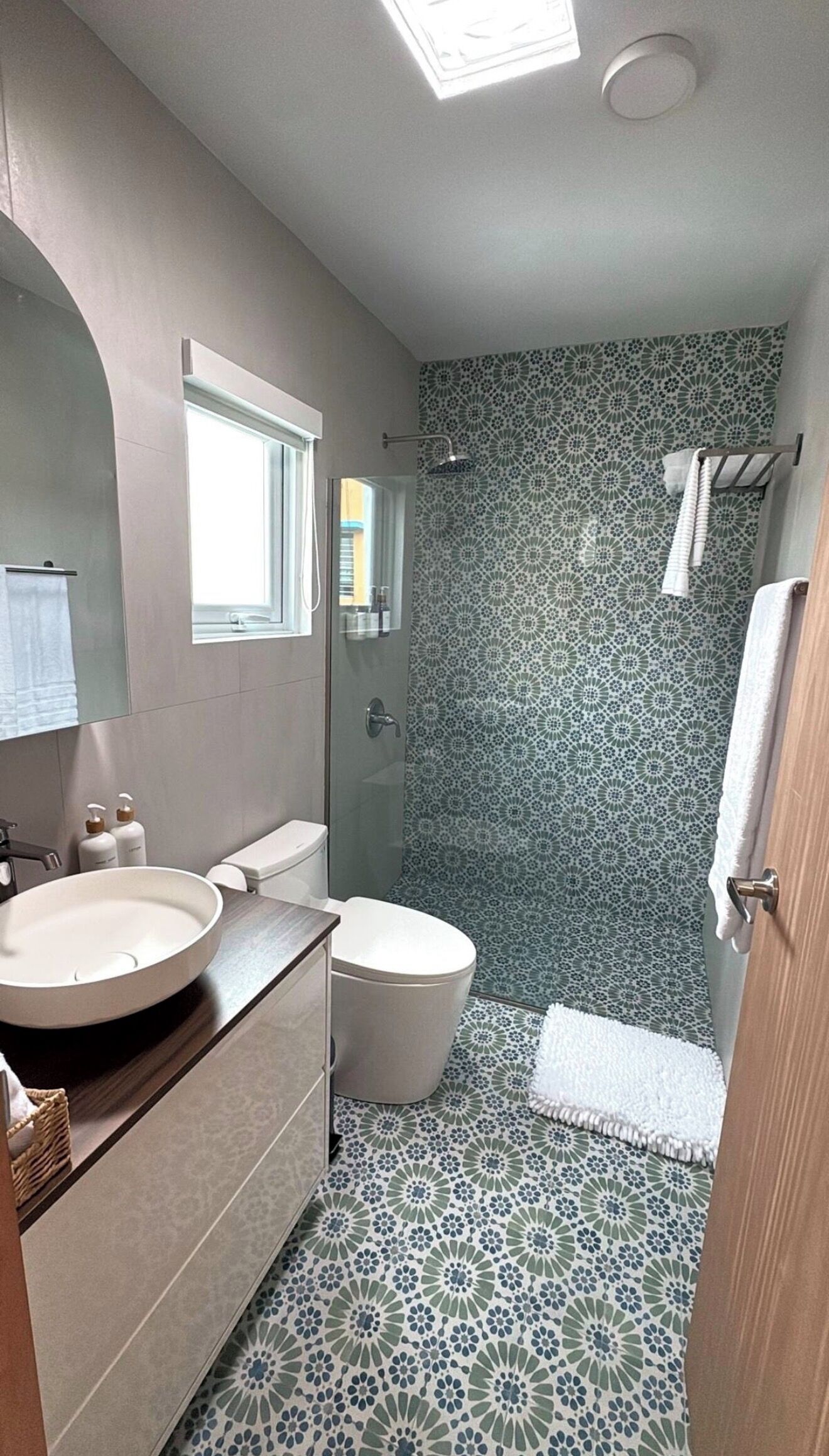 A bathroom with a round sink, toilet, and shower.