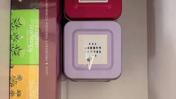 Een opslagruimte met drie containers, gelabeld 'English Tea Shop Organic' en 'Garden Secret Tea'.