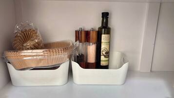 Un piano di lavoro in cucina con contenitori portaoggetti contenenti diversi utensili da cucina.
