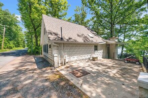 A single-story house with a sloped roof, a front porch, and a small attached garage. - Lakeshore Pines: Cozy Keuka Lake Retreat! (Penn Yan)