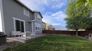 A residential backyard with a lawn, patio furniture, and a wooden fence. - 5B4B in Parker w/ Game Room, Fenced Yard & Garage (Parker)
