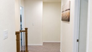 A carpeted hallway with a door on the right and a window on the left. - 5B4B in Parker w/ Game Room, Fenced Yard & Garage (Parker)