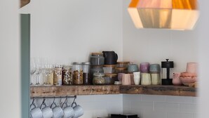 A kitchen with a wooden countertop, various jars, glasses, and utensils. - Pippis Cottage, bringing back the charm of the iconic old Bendalong School House (Bendalong)