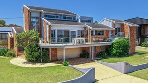 A two-story house with a balcony, a garage, and a well-maintained lawn. - The Lookout Manyana, Ocean views to GreenIsland and over Manyana Beach (Manyana)