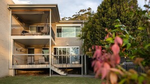 Un bâtiment moderne à deux étages, doté d’un toit plat, de grandes fenêtres et d’un balcon à l’étage supérieur.