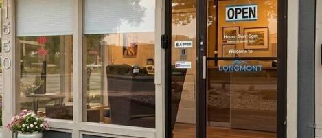 A building with a large glass door, a sign reading 'OPEN', and the number '1550'.