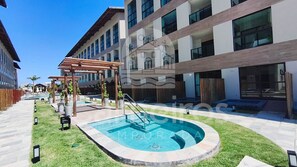 Un bâtiment moderne doté d’une piscine, d’un espace extérieur aménagé et d’une pergola.