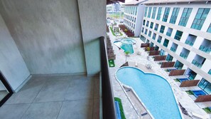 A hotel with a pool area, multiple balconies, and a modern building facade. - Max Carneiros Suítes  (Tamandaré)