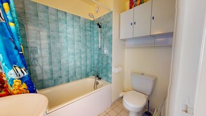 Une salle de bain avec une baignoire, des toilettes et une douche.