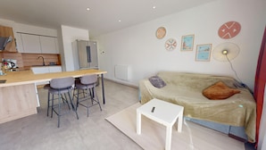 A modern apartment with a kitchen, dining area, and living room. - Le Cocon de la Paludiere (Le Pouliguen)