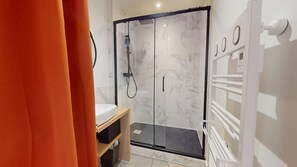 Un bagno moderno con doccia vetro, mobile bagno in legno e termosifone bianco.