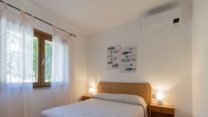 A bedroom with a bed, two bedside tables, a window with curtains, and wall art. - Fantastic sea view and privacy (Lacona)