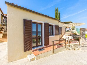 A two-story building with a beige exterior, brown shutters, and a stone staircase leading to the upper floor. - Sea-view one-bedroom apartment in Portoferraio (Portoferraio)