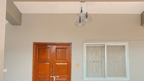 Unas puertas dobles de madera, una ventana con celosía decorativa y una balaustrada blanca.