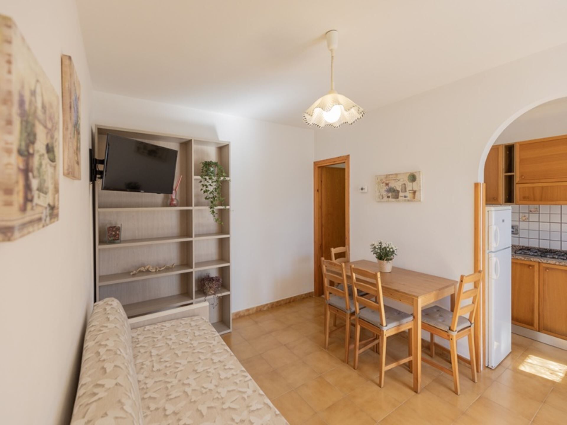 A compact living space with a dining area, kitchenette, and a sofa.