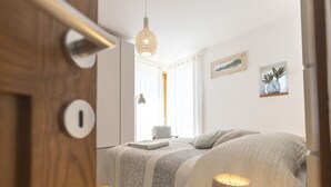 A bedroom with a bed, bedside lamp, and a door.