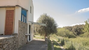 A white building with a stone base, a wooden door, and a blue window shutter. - Perfect for couples, independent and on two levels (Rio Marina)