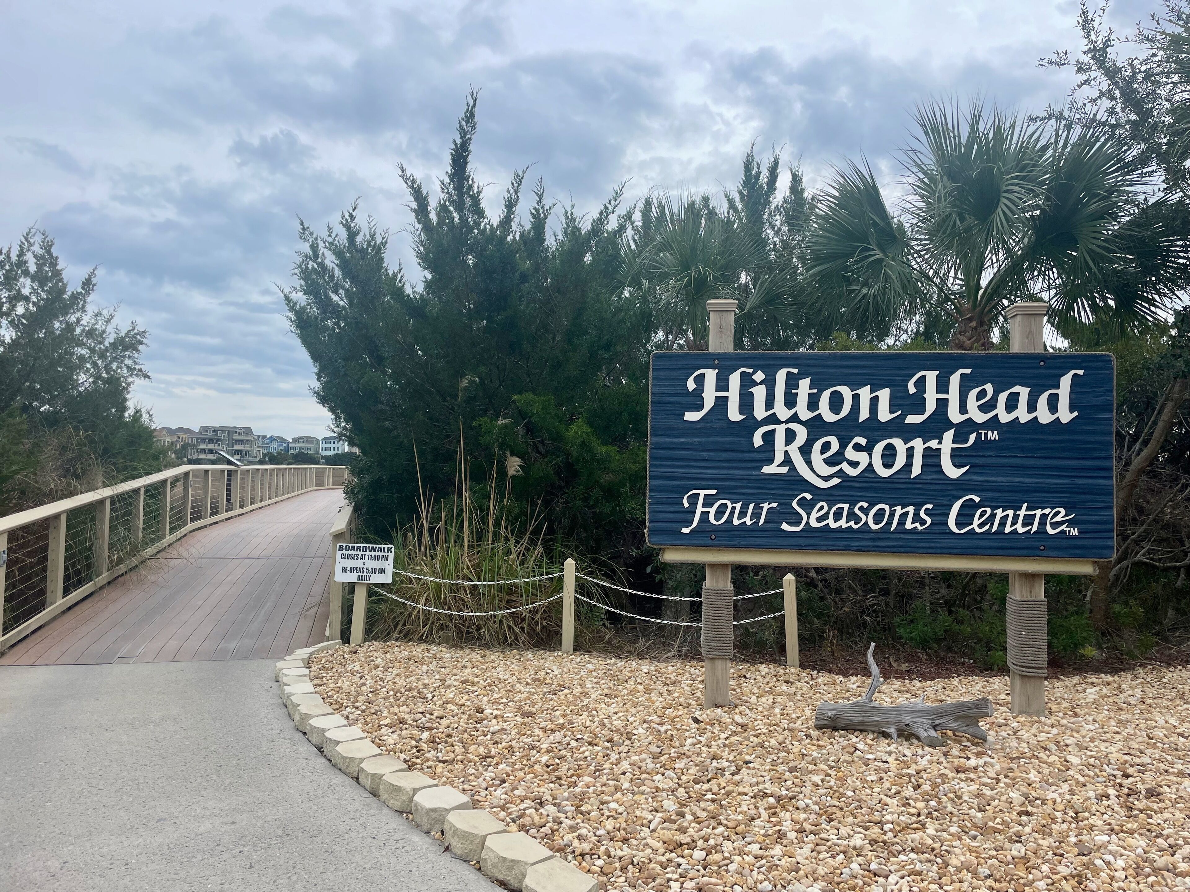 A sign for Hilton Head Resort's Four Seasons Centre, with a boardwalk leading to the property.