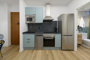 A compact kitchen with a microwave, stove, and refrigerator. - GRAN VIA capitals, MaRRAKECH (Madrid)