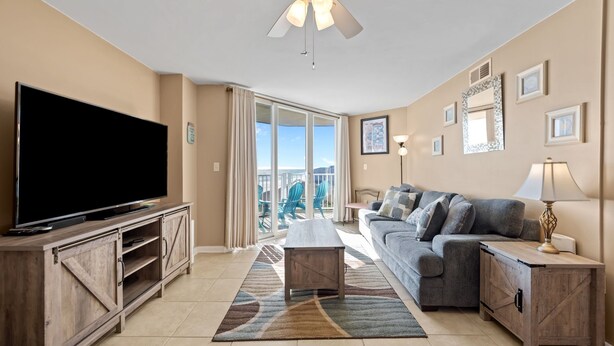 A living room with a flat-screen TV, a sofa, a coffee table, and a ceiling fan. - Oceanfront Balcony Views at Dolphin Sightings (North Topsail Beach)