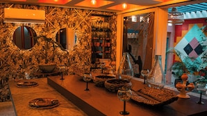 Una zona de bar con una barra larga, varios vasos y adornos decorativos.