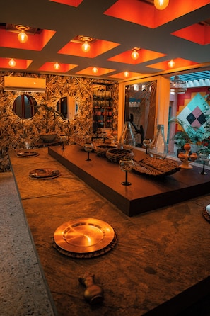 A bar area with a long counter, multiple glasses, and decorative items.