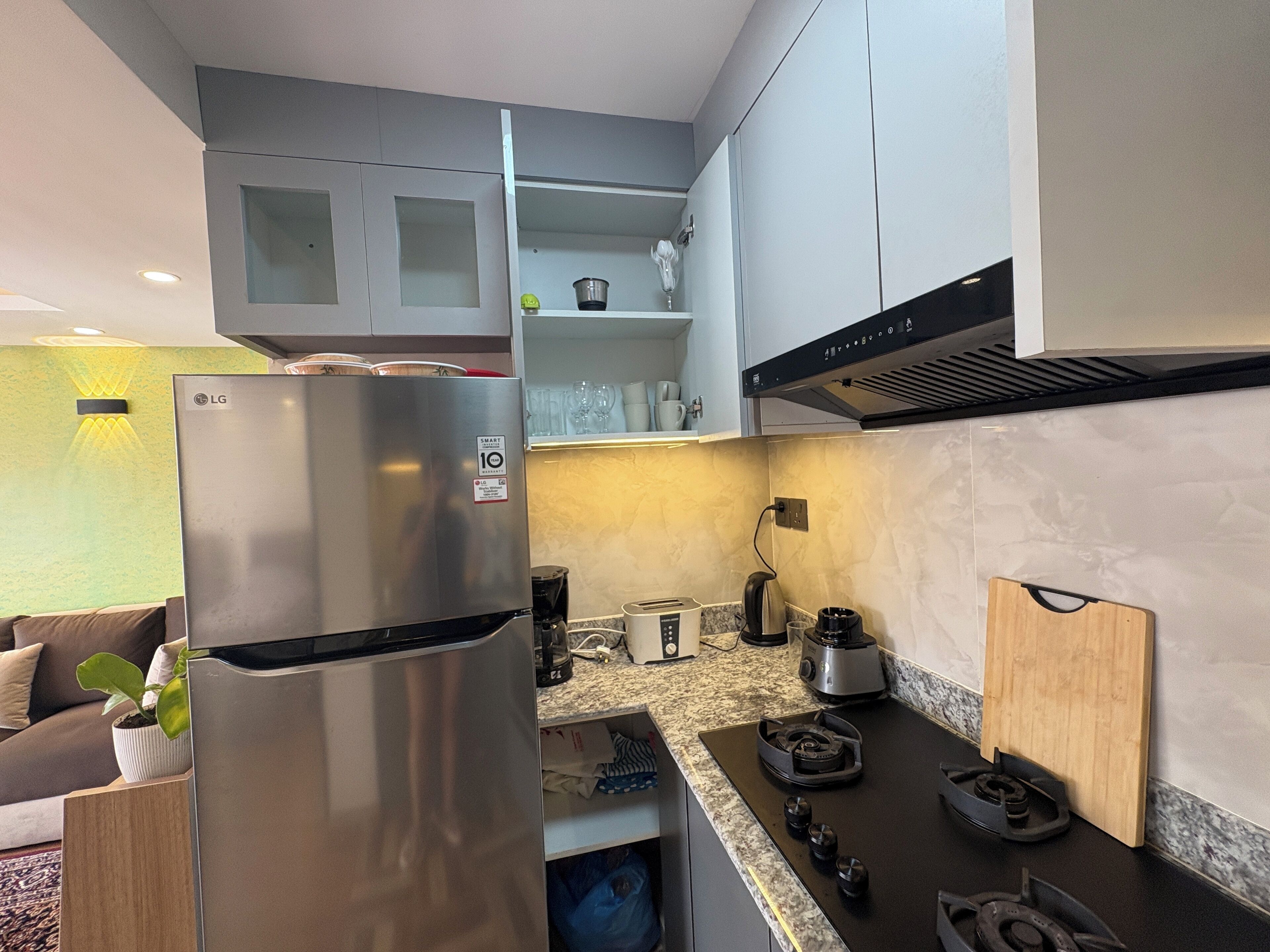 Eine moderne Küche mit einem Edelstahlkühlschrank, einem Gasherd und einem eingebauten Backofen.