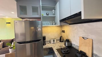 Eine moderne Küche mit einem Edelstahlkühlschrank, einem Gasherd und einem eingebauten Backofen.