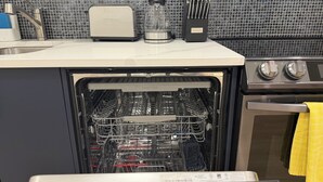 A kitchen with a dishwasher, a toaster, and a kettle. - Modern 1BR Private Suite Near Airport and Amazing Shopping!Free Netflix, Parking (Calgary)