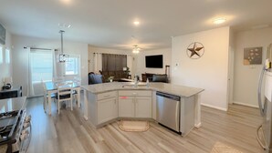 Una cucina moderna con isola centrale, elettrodomestici integrati e zona pranzo con tavolo e sedie.