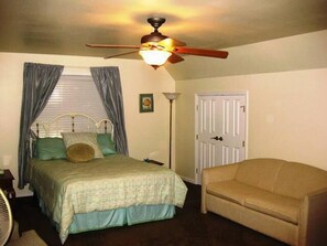 A bedroom with a bed, a ceiling fan, a door, and a chair. - Lile II, West in Lake Almanor West, CA (Lake Almanor West)