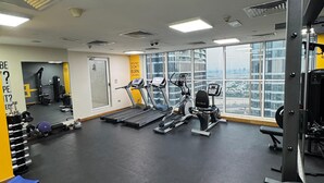 Ein Fitnessstudio mit Laufbändern, Krafttrainingsgeräten und Kurzhanteln.