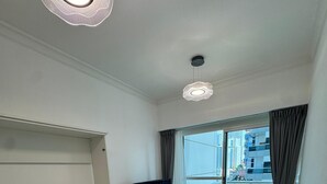 Ein modernes Hotelzimmer mit einem großen Bett, einer Sitzecke, einem Fernseher und einem Balkon mit Blick auf die Stadt.