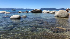 A clear lake with large rocks and mountains in the background. - Kings Beach Studio • Pool, Hot Tub, SUP, & Sauna • Kings Beach & Northstar (Tahoe Vista)